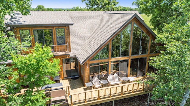 69125 E 252nd Rd, Wyandotte, OK 74370 - rear view of house featuring a sunroom, a deck, and a shingled roof