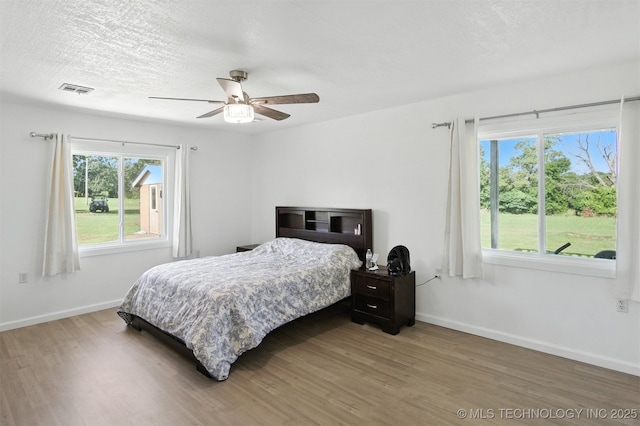 27719 S 610th Rd, Bunch, OK 74931 - bedroom with wood finished floors, multiple windows, and a ceiling fan