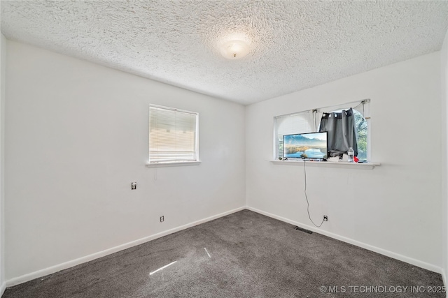 8817 E 2nd St, Tulsa, OK 74112 - carpeted empty room with a textured ceiling and baseboards