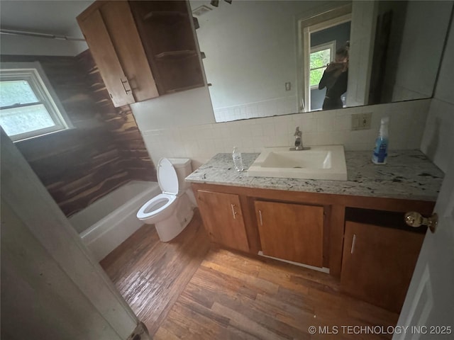 512 S Jules Ave, Cleveland, OK 74020 - full bath with vanity, wood finished floors, bathing tub / shower combination, and tasteful backsplash