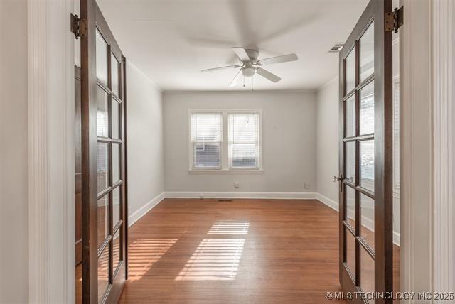 1531 S Florence Ave, Tulsa, OK 74104 - unfurnished room featuring wood finished floors, a ceiling fan, and french doors
