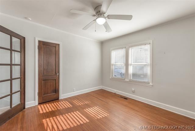 1531 S Florence Ave, Tulsa, OK 74104 - empty room with wood finished floors, ceiling fan, and crown molding