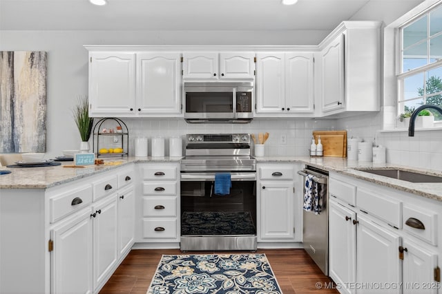 2117 Western Dr, Skiatook, OK 74070 - kitchen featuring stainless steel appliances, white cabinetry, recessed lighting, tasteful backsplash, and light stone counters