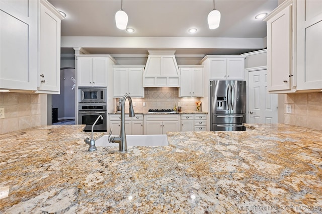 9319 S Indianapolis Ave, Tulsa, OK 74137 - kitchen featuring appliances with stainless steel finishes, premium range hood, backsplash, light stone countertops, and white cabinetry