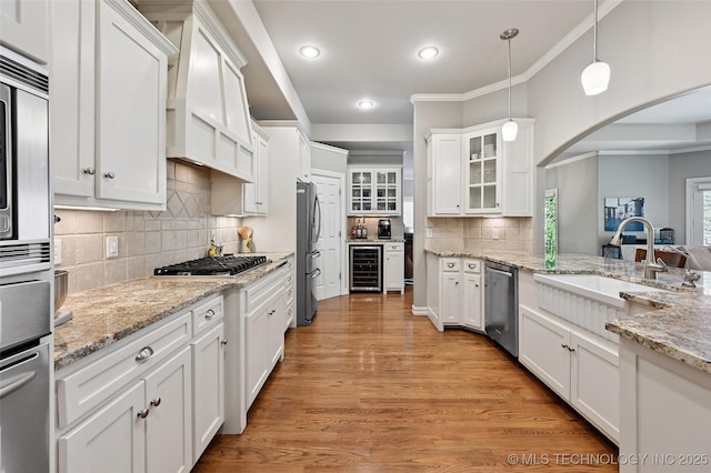 9319 S Indianapolis Ave, Tulsa, OK 74137 - kitchen featuring wine cooler, stainless steel appliances, crown molding, white cabinets, and arched walkways