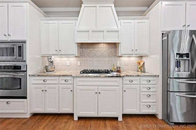 9319 S Indianapolis Ave, Tulsa, OK 74137 - kitchen with stainless steel appliances, custom exhaust hood, white cabinets, crown molding, and decorative backsplash