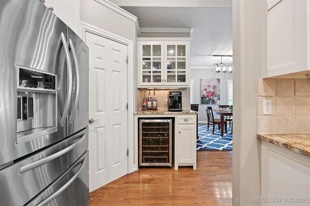 9319 S Indianapolis Ave, Tulsa, OK 74137 - kitchen featuring stainless steel refrigerator with ice dispenser, wine cooler, light wood finished floors, white cabinetry, and ornamental molding