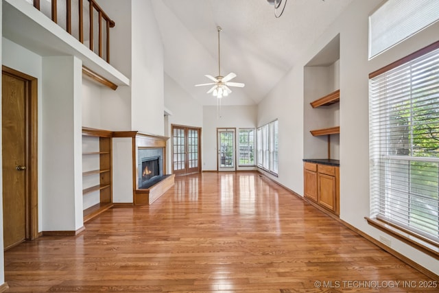 5117 E 89th St, Tulsa, OK 74137 - unfurnished living room featuring light wood finished floors, high vaulted ceiling, a tiled fireplace, and ceiling fan