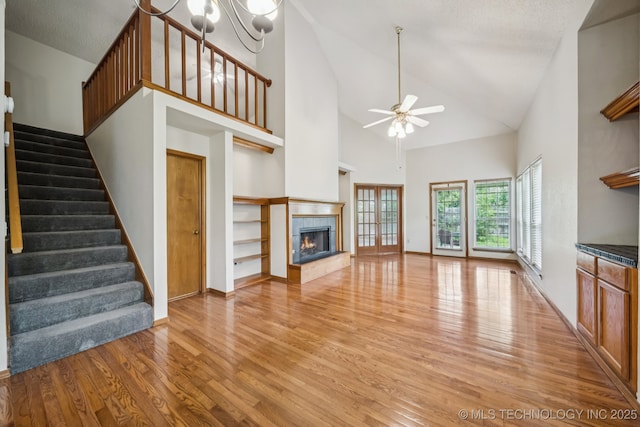 5117 E 89th St, Tulsa, OK 74137 - unfurnished living room with light wood finished floors, stairway, a fireplace, and high vaulted ceiling