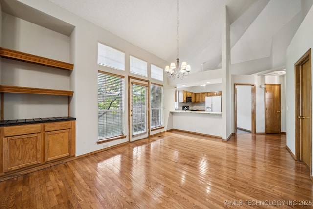 5117 E 89th St, Tulsa, OK 74137 - unfurnished living room with a chandelier, light wood-style flooring, and high vaulted ceiling