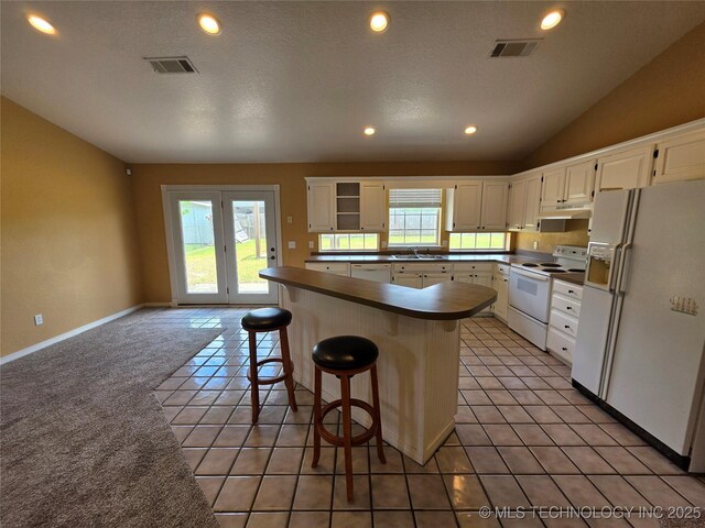 2202 Sycamore Rd, Mcalester, OK 74501 - kitchen with white appliances, white cabinetry, lofted ceiling, under cabinet range hood, and recessed lighting