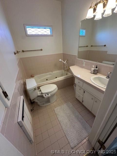 717 N Burns, Holdenville, OK 74848 - full bathroom featuring a tub with jets, vanity, tile patterned floors, tile walls, and a chandelier