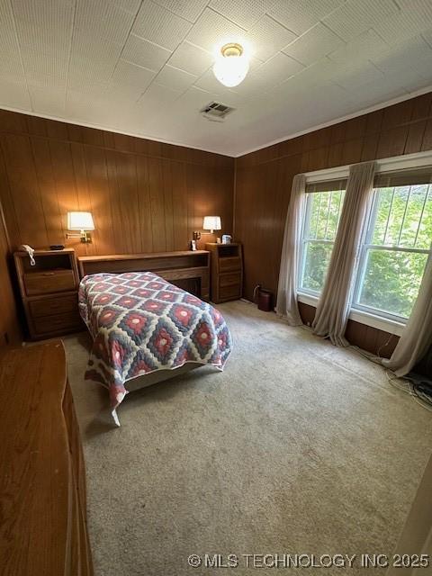 717 N Burns, Holdenville, OK 74848 - bedroom featuring light carpet and wood walls