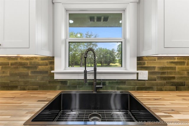 16355 County Road 1586, Ada, OK 74820 - kitchen view of butcher block countertops, white cabinets, and backsplash