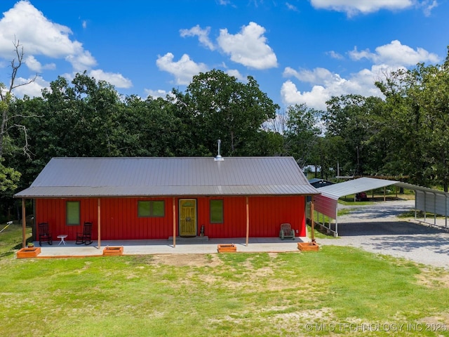 346 2570th Rd, Bartlesville, OK 74003 - view of front of property with board and batten siding, a front yard, gravel driveway, and a metal roof