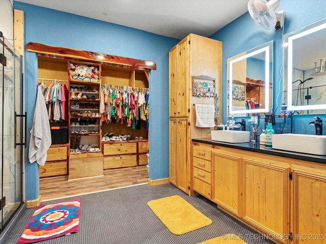 346 2570th Rd, Bartlesville, OK 74003 - bathroom featuring a stall shower, double vanity, and a walk in closet