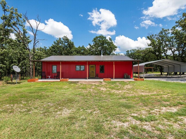 346 2570th Rd, Bartlesville, OK 74003 - rear view of house with a yard, a metal roof, a carport, and driveway