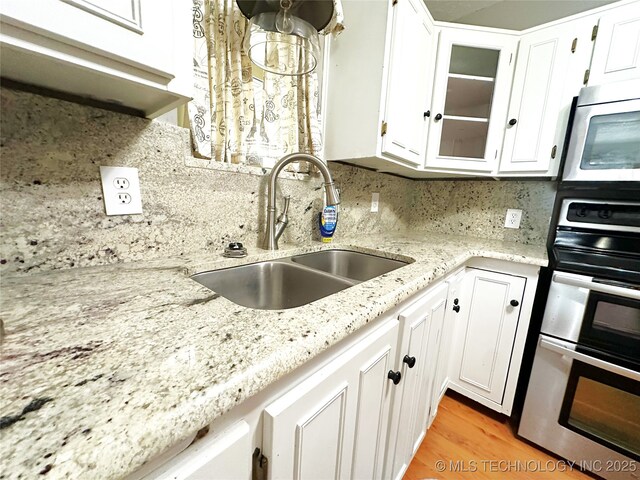 5371 Hilltop, Mcalester, OK 74501 - kitchen with stainless steel appliances, white cabinetry, and tasteful backsplash
