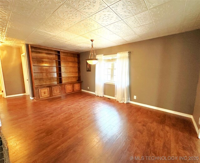 5371 Hilltop, Mcalester, OK 74501 - unfurnished living room featuring built in shelves, wood finished floors, and an ornate ceiling