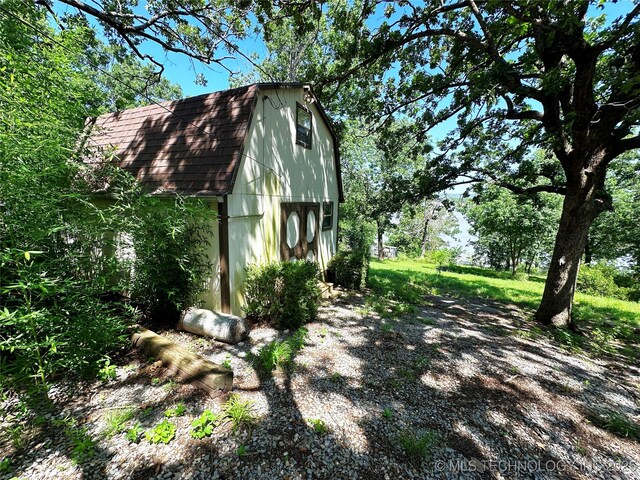 5371 Hilltop, Mcalester, OK 74501 - view of home's exterior featuring a gambrel roof, an outdoor structure, and roof with shingles