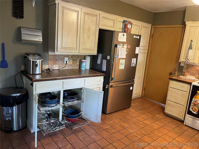 2509 Canterbury Ave, Muskogee, OK 74403 - kitchen featuring freestanding refrigerator, tasteful backsplash, light tile patterned floors, and dark countertops