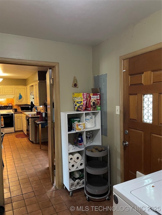 2509 Canterbury Ave, Muskogee, OK 74403 - kitchen with white electric stove, tile patterned floors, light brown cabinets, and washer / clothes dryer