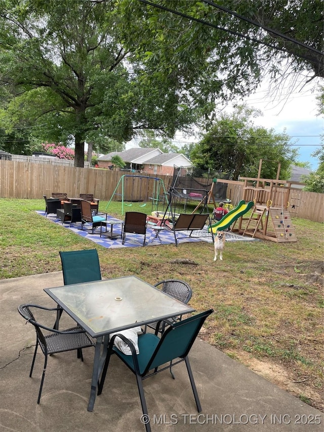 2509 Canterbury Ave, Muskogee, OK 74403 - fenced backyard with a playground, outdoor dining area, a patio, and outdoor lounge area