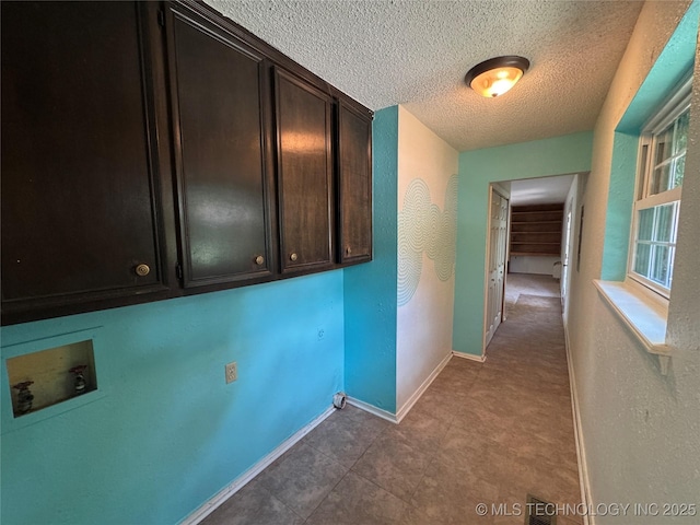 1516 Timber Ridge Dr, Cleveland, OK 74020 - laundry room featuring hookup for a washing machine, a textured ceiling, cabinet space, and a textured wall
