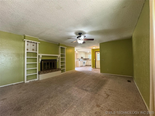 1516 Timber Ridge Dr, Cleveland, OK 74020 - unfurnished living room with a ceiling fan, carpet flooring, a glass covered fireplace, a textured wall, and a textured ceiling