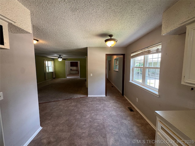 1516 Timber Ridge Dr, Cleveland, OK 74020 - unfurnished dining area featuring ceiling fan, dark flooring, and a textured ceiling