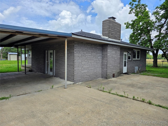 6850 E County Road 553, Kansas, OK 74347 - view of side of home featuring a chimney, a storage shed, brick siding, and a patio