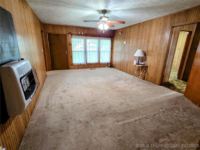 6850 E County Road 553, Kansas, OK 74347 - unfurnished living room featuring carpet floors, heating unit, ceiling fan, and wooden walls