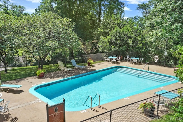 1500 S Frisco Ave Unit 1E, Tulsa, OK 74119 - community pool featuring a patio area, a fenced backyard, and view of wooded area