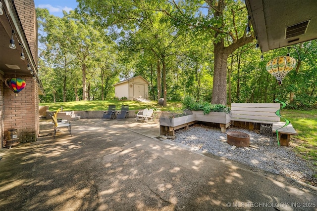 16 Big Bluff St, Pryor, OK 74361 - view of patio / terrace with an outdoor fire pit, a storage shed, and view of wooded area