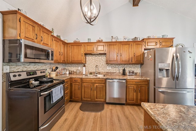 16 Big Bluff St, Pryor, OK 74361 - kitchen with stainless steel appliances, light wood-style floors, brown cabinetry, decorative backsplash, and high vaulted ceiling