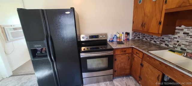 1763 Bryan St, Westville, OK 74965 - kitchen with black fridge, stainless steel range with electric stovetop, brown cabinetry, tasteful backsplash, and a wall mounted air conditioner