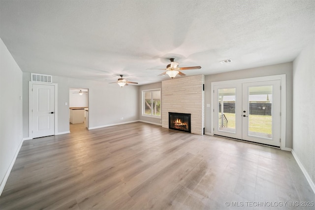 215 S Elliott St, Pryor, OK 74361 - unfurnished living room featuring healthy amount of natural light, a ceiling fan, french doors, and a textured ceiling