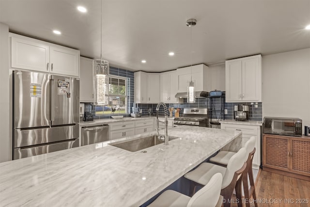 5951 E 25th Pl S, Tulsa, OK 74114 - kitchen featuring appliances with stainless steel finishes, light stone countertops, recessed lighting, backsplash, and pendant lighting