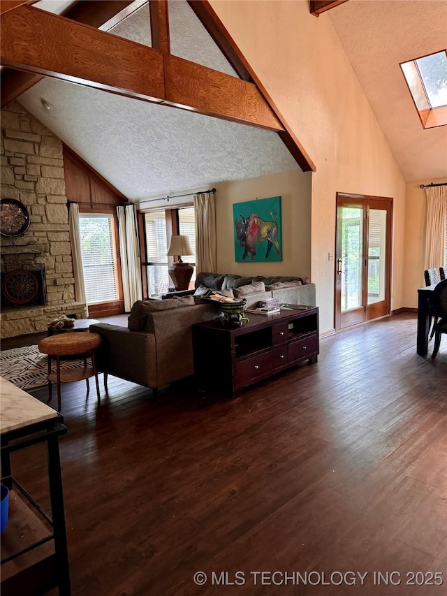 8448 S Florence Ave, Tulsa, OK 74137 - living area featuring high vaulted ceiling, a skylight, beam ceiling, dark wood-type flooring, and a fireplace