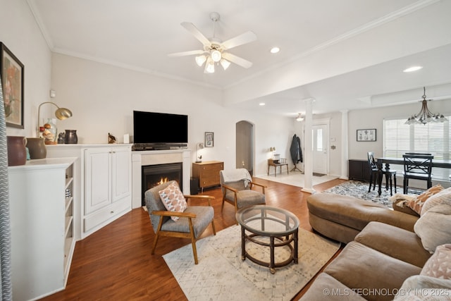 8931 E 62nd Pl, Tulsa, OK 74133 - living room featuring arched walkways, dark wood-type flooring, a ceiling fan, recessed lighting, and ornamental molding