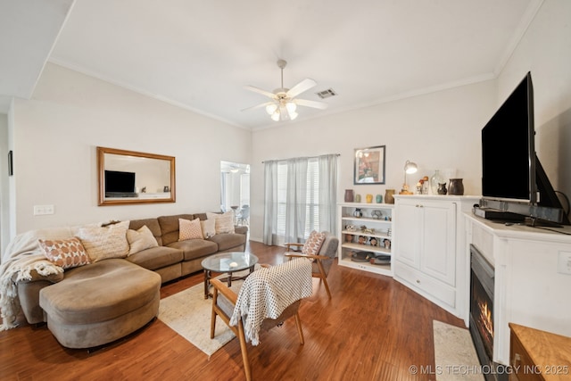 8931 E 62nd Pl, Tulsa, OK 74133 - living room featuring wood finished floors, ceiling fan, a fireplace with flush hearth, and crown molding