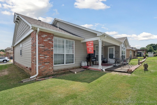 8931 E 62nd Pl, Tulsa, OK 74133 - view of front of house with brick siding, a front lawn, ceiling fan, roof with shingles, and a patio