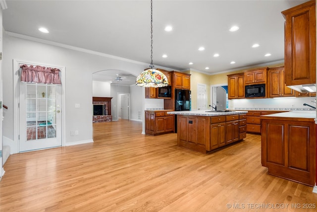 8710 S Vandalia Ave, Tulsa, OK 74137 - kitchen with black appliances, ornamental molding, brown cabinetry, light countertops, and an island with sink