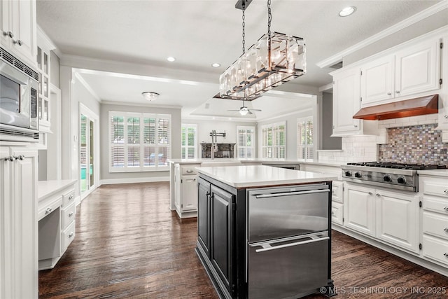 10150 S Maplewood Ave, Tulsa, OK 74137 - kitchen with crown molding, light countertops, appliances with stainless steel finishes, white cabinetry, and tasteful backsplash
