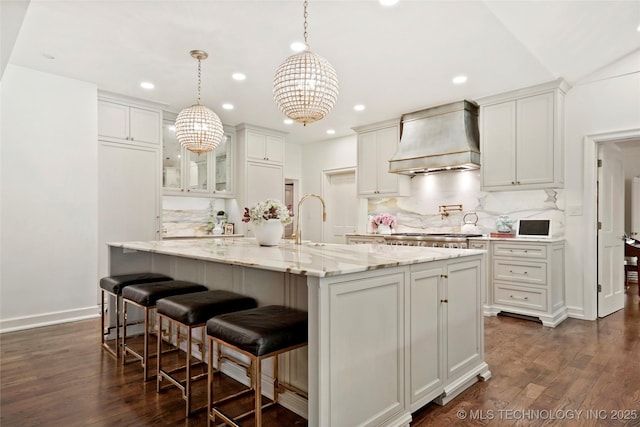 1111 E 24th Pl, Tulsa, OK 74114 - kitchen featuring premium range hood, decorative backsplash, dark wood finished floors, recessed lighting, and light stone countertops
