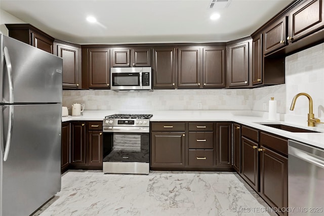 1111 E 24th Pl, Tulsa, OK 74114 - kitchen featuring appliances with stainless steel finishes, dark brown cabinetry, light countertops, backsplash, and light marble finish floors
