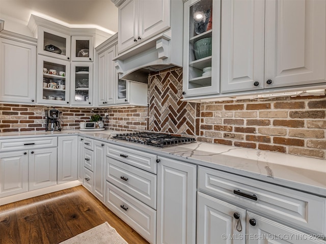 20853 S 81st Ave W, Mounds, OK 74047 - kitchen with stainless steel gas stovetop, white cabinets, light stone countertops, under cabinet range hood, and wood finished floors