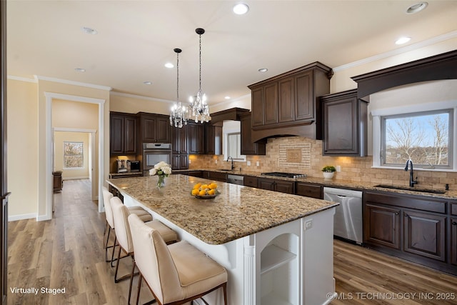 16511 S 4230th Rd, Claremore, OK 74017 - kitchen with stainless steel appliances, dark brown cabinets, decorative backsplash, light stone counters, and a center island