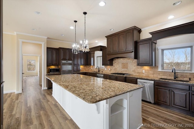 16511 S 4230th Rd, Claremore, OK 74017 - kitchen with stainless steel appliances, dark brown cabinets, a center island, tasteful backsplash, and crown molding