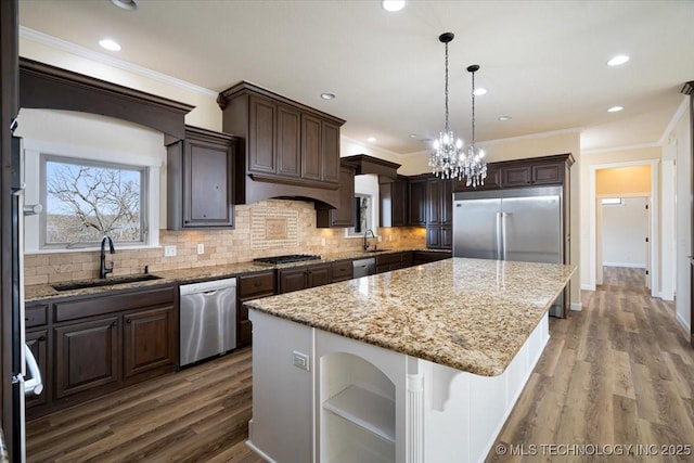 16511 S 4230th Rd, Claremore, OK 74017 - kitchen with appliances with stainless steel finishes, a kitchen island, dark brown cabinetry, tasteful backsplash, and crown molding